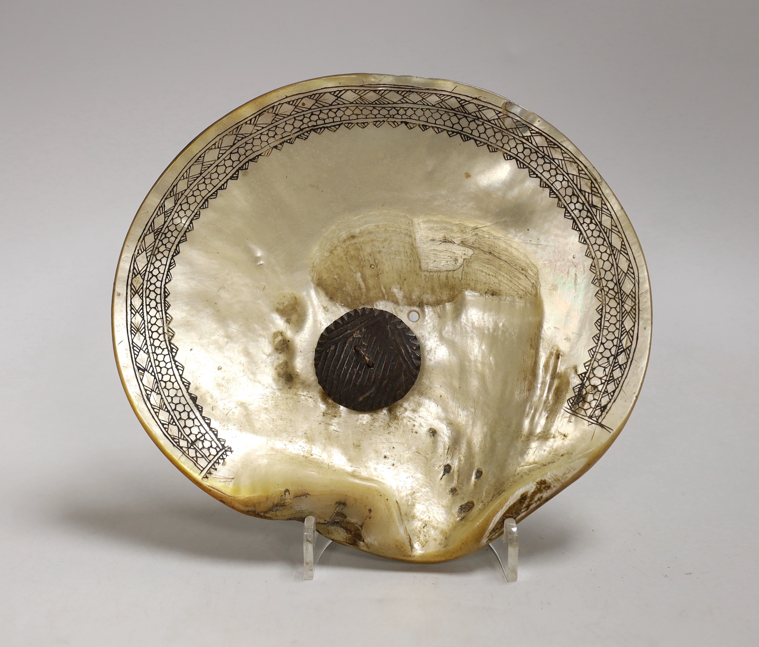 Bontoc Tribe, Luzon, North Island Philippines, a fikum hip decoration, engraved mother of pearl shell, 18cm., Provenance – a European Private collection, thence by family descent. Ethnographica from the same collection w